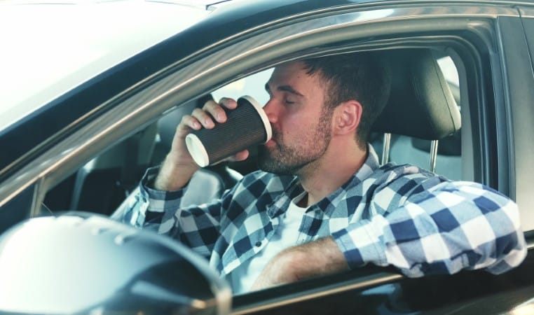 Guy enjoying coffee while sitting in the car. Slow motion