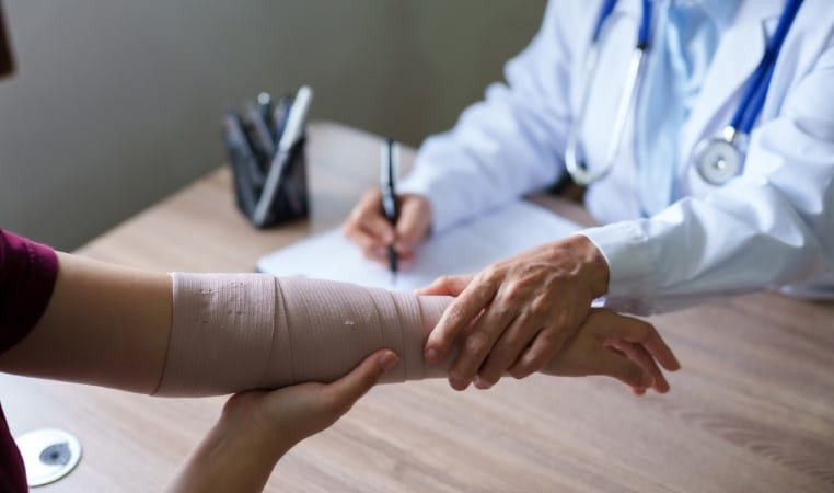 Doctor is examining the arm of a female